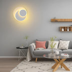 A modern LED wall sconce emits a soft yellow glow, creating warm, ambient lighting.