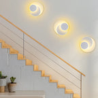 Two ORLUNE HOME LED wall sconces cast a soft, modern yellow glow on the staircase.