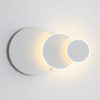 Soft, adjustable LED circles create a minimalist glow for subtle, modern wall lighting.