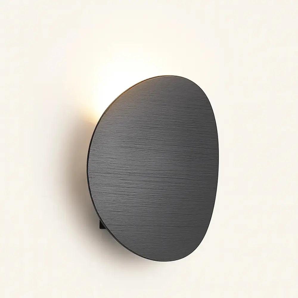 Soft backlit LED wall light, matte black shade, clean minimalist glow for modern ambiance.