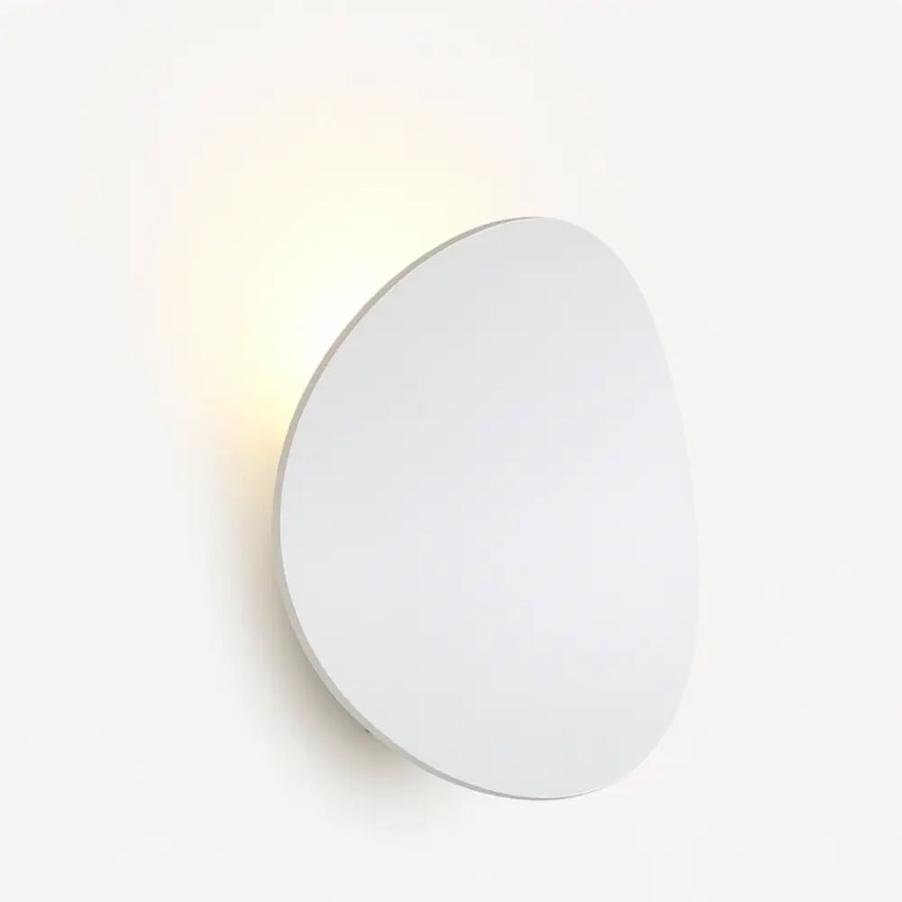 Soft, warm ambient light radiates from a modern round LED wall fixture, elegantly illuminating.